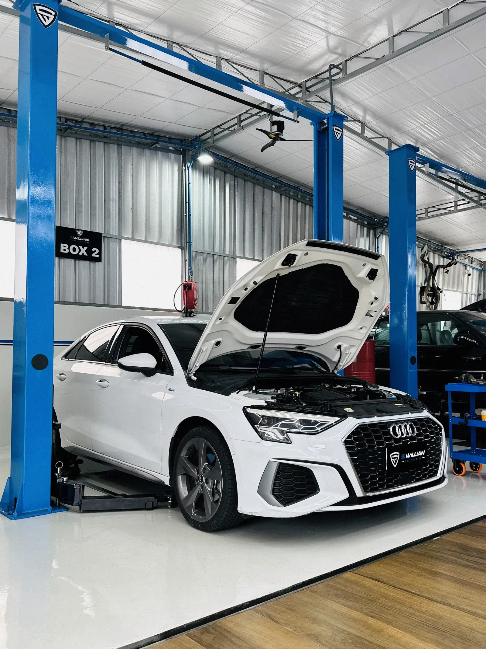 Audi A3 branco com o capô aberto no boxe 2