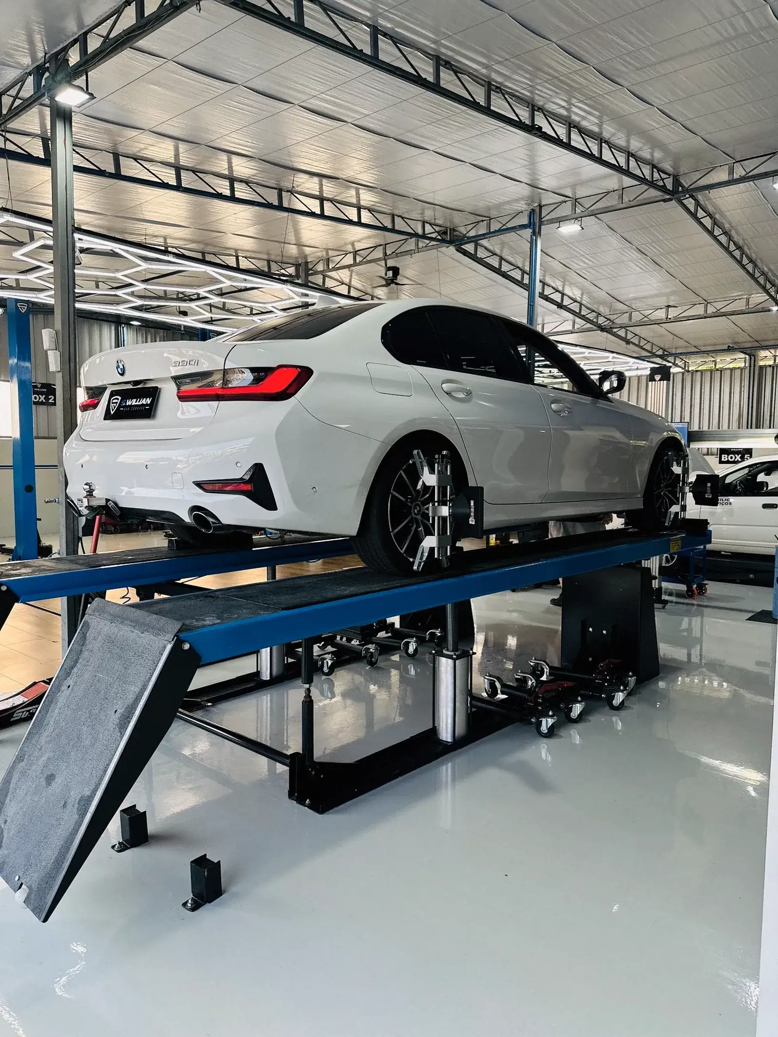 BMW 320i branco no alinhador de rodas, boxe 2