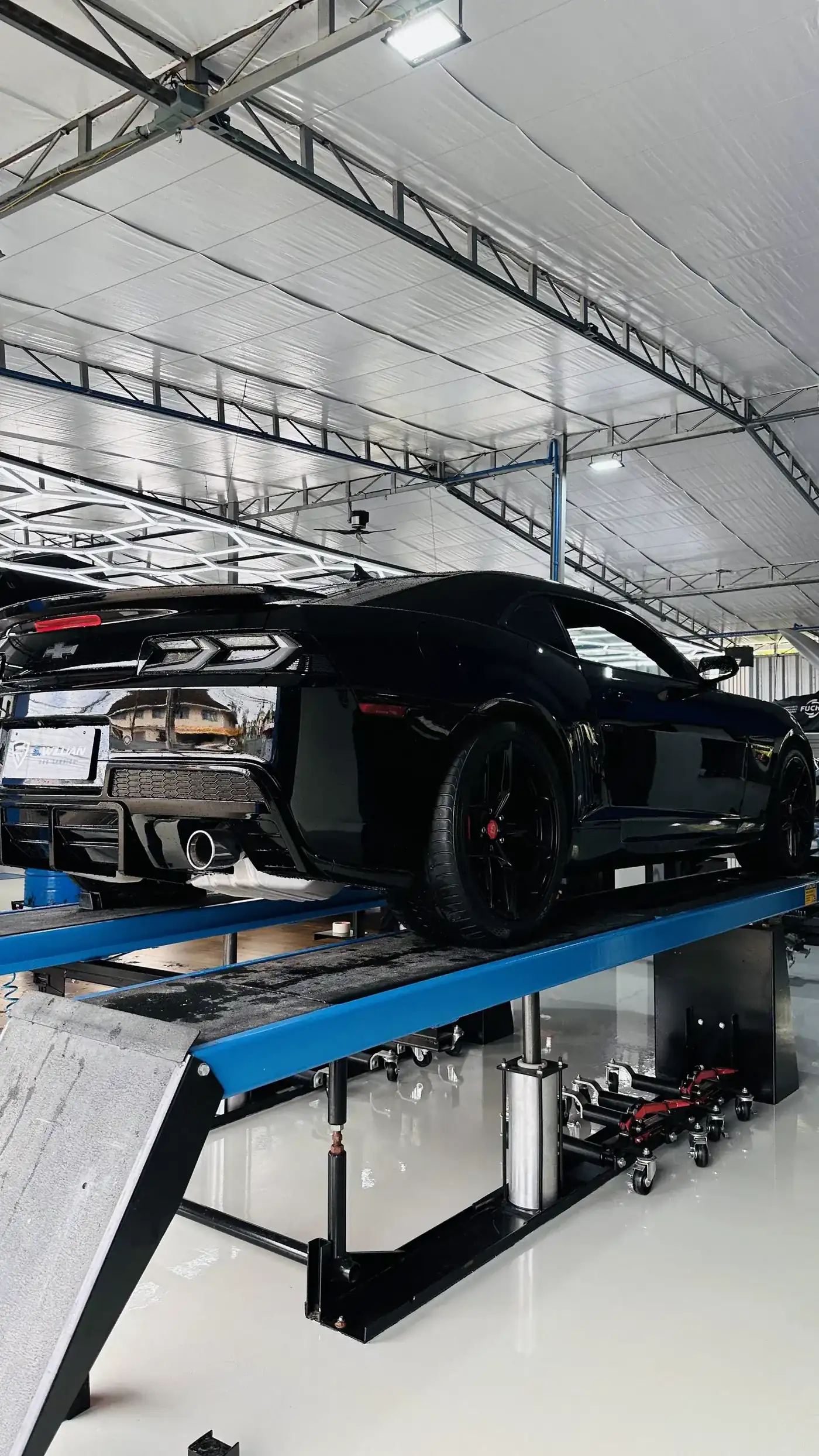 Chevrolet Camaro preto no elevador de 4 colunas