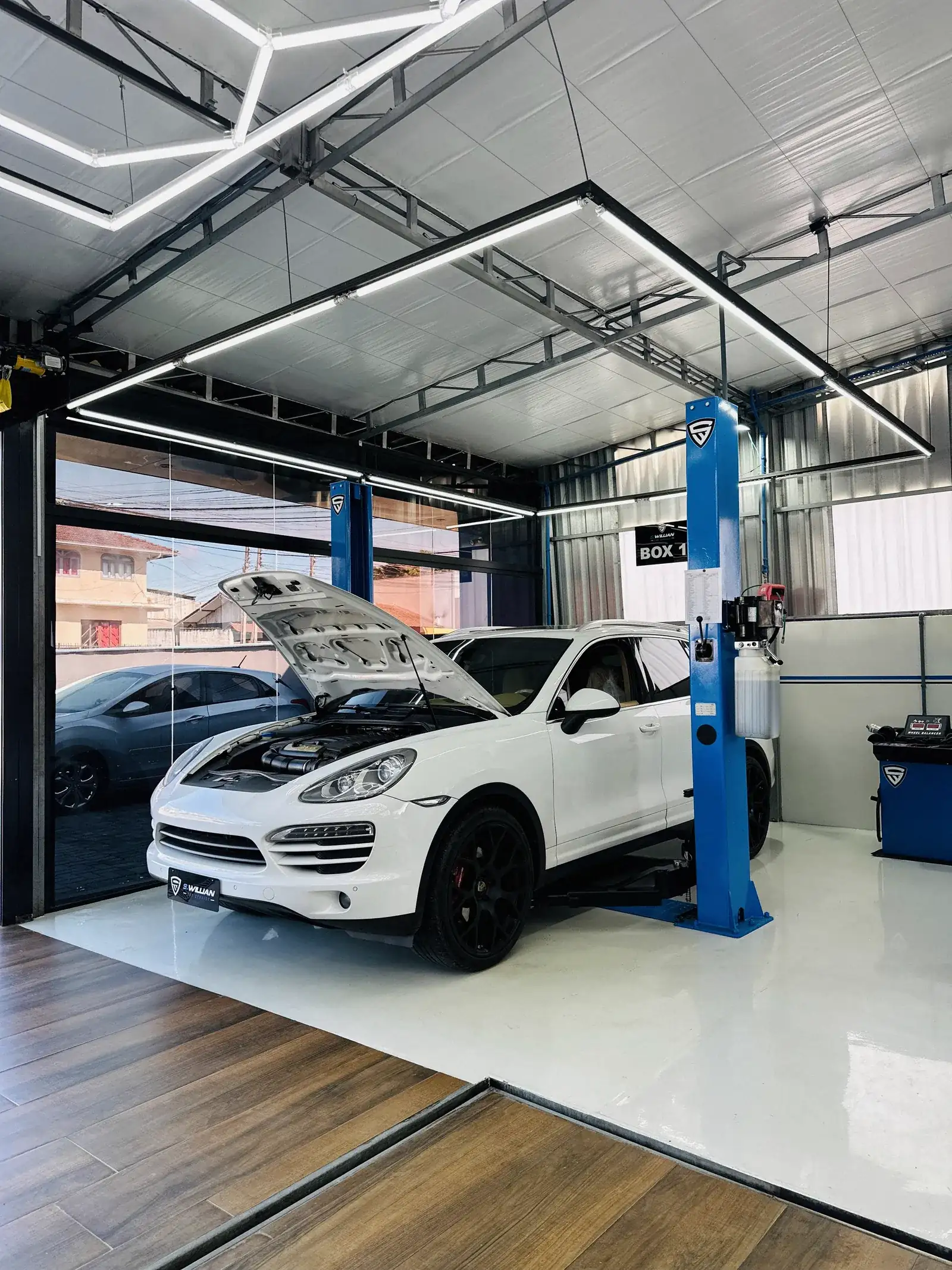 Porsche Cayenne com o capô aberto no elevador