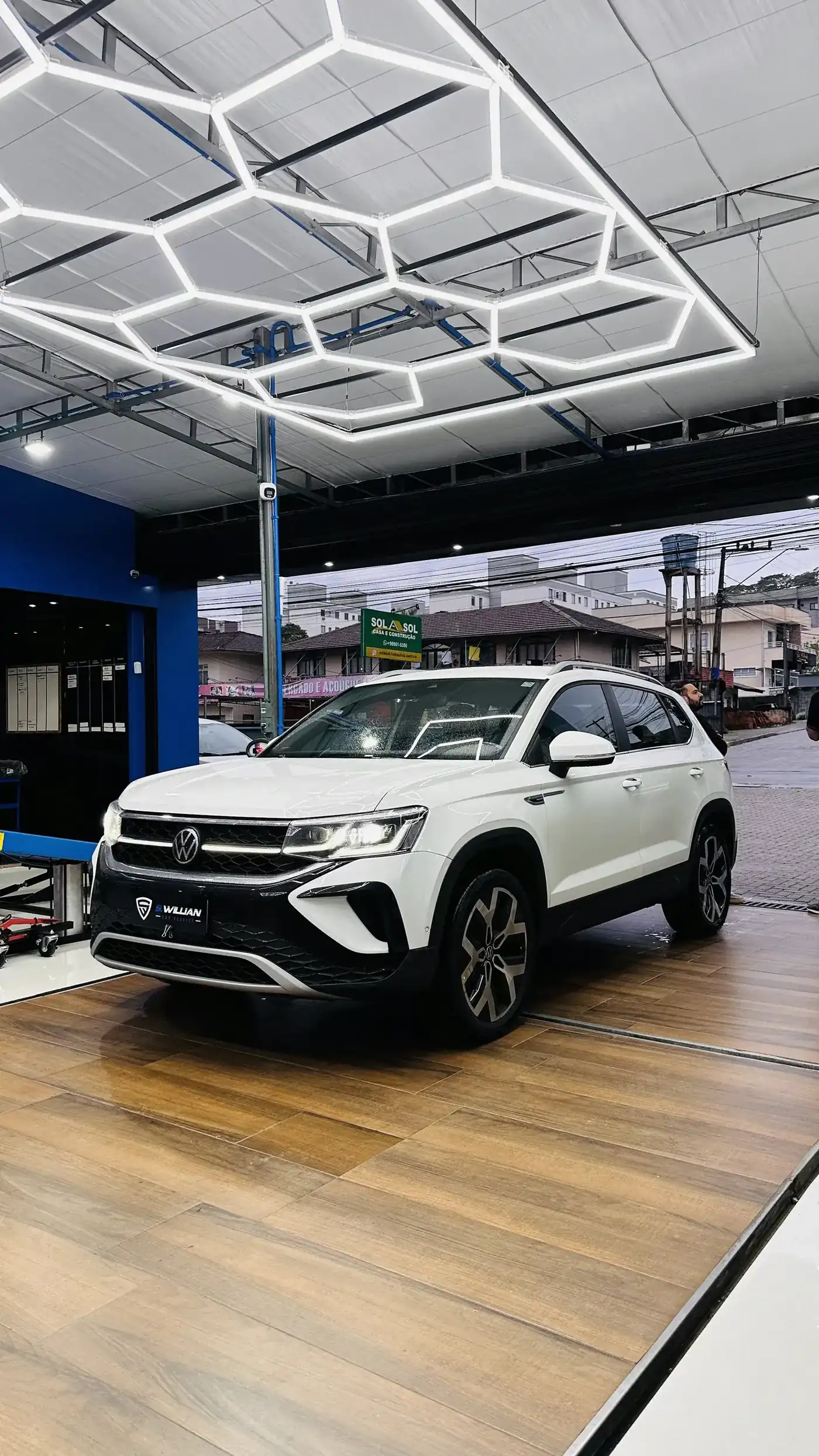 Volkswagen Taos branco sob o teto hexagonal de LED